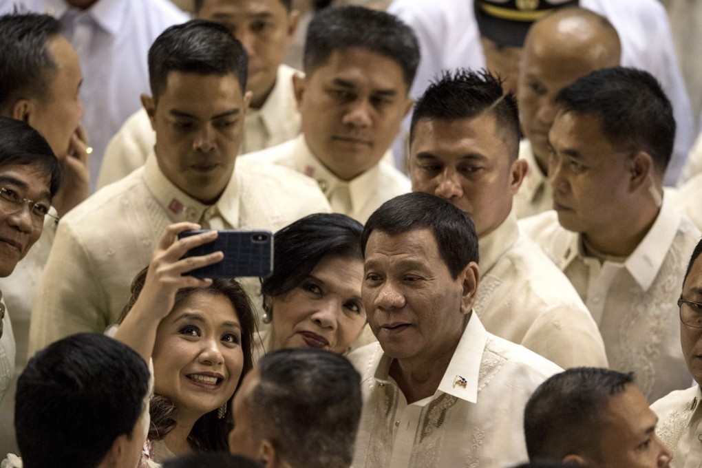 Philippine President Rodrigo Duterte poses for a selfie with supporters and lawmakers after delivering his state of the nation address at Congress in Manila on July 23. Photo: AFP