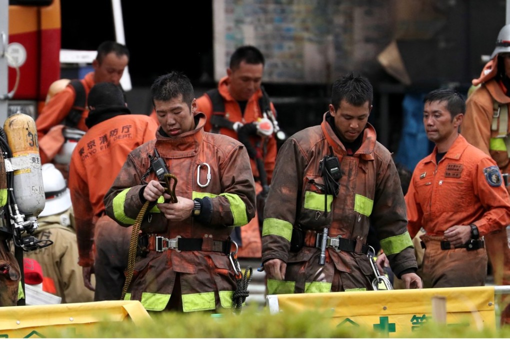 Firefighters leave a building construction site where a fire broke out in Tama, suburban Tokyo, on Thursday. Photo: EPA