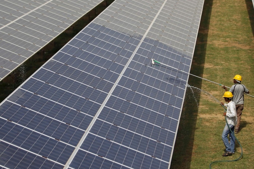 Workers clean a solar power plant in Gujarat, India. Photo: Reuters