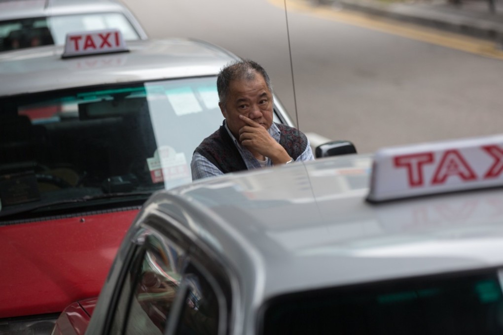 A taxi driver stands next to his car parked in front of the Legislative Council on March 15, during a protest to demand that the Hong Kong government ban Uber. Photo: EPA-EFE