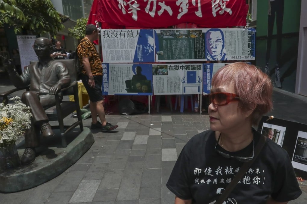 Activist Vivian with the statue of Liu Xiaobo on Paterson Street, in Causeway Bay. Picture: Jonathan Wong