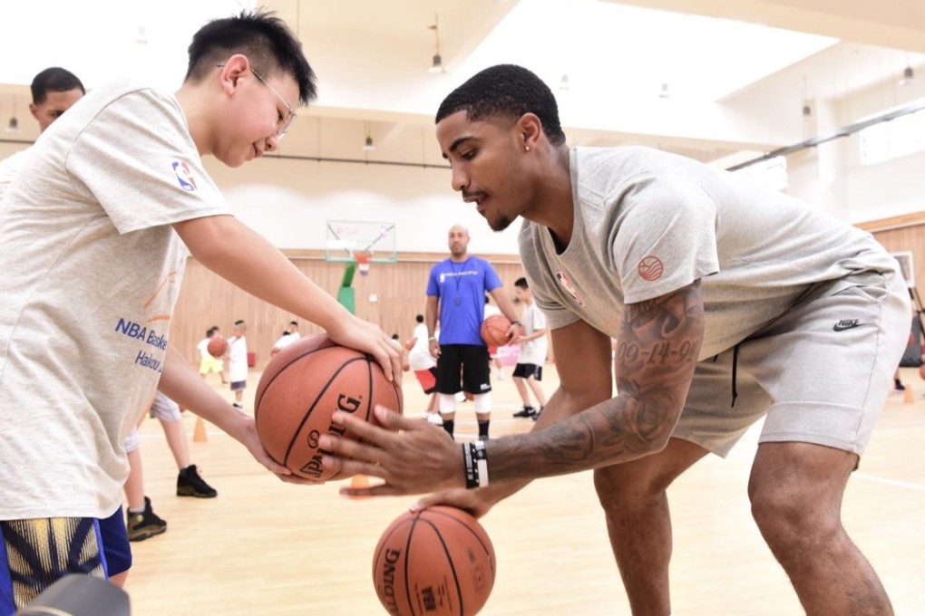 Harris teaches a young Chinese basketball player some basic handles. Photo: Mission Hills