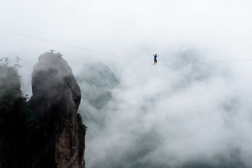 A slackline walker takes his chance up in air during a challenge held in Taizhou in east China’s Zhejiang province in May 2016. Chinese authorities have to grapple with both the implications of the trade war with the US and their own commitment to deleveraging. Photo: Xinhua