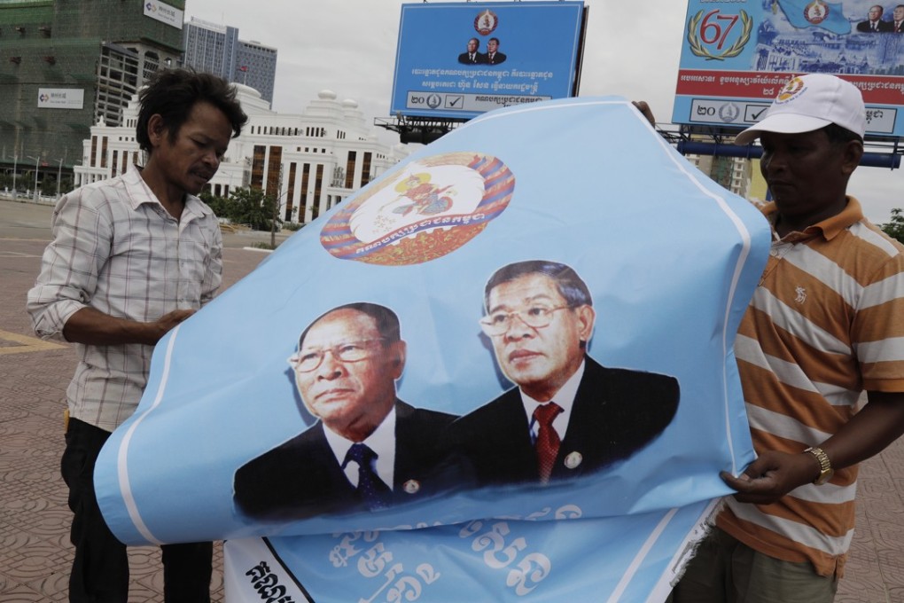 Cambodian workers fold a poster with portraits of Prime Minister Hun Sen and President of the National Assembly Heng Samrin after the national elections in Phnom Penh, Cambodia, July 30, 2018. Photo: EPA
