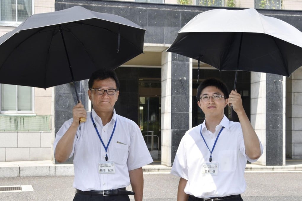 Promoting parasols for men in Japan, Saitama prefectural government officials Noriaki Fukuhara (left) and Takeshi Okumura stand outside the local government office in Saitama near Tokyo. Photo: Kyodo