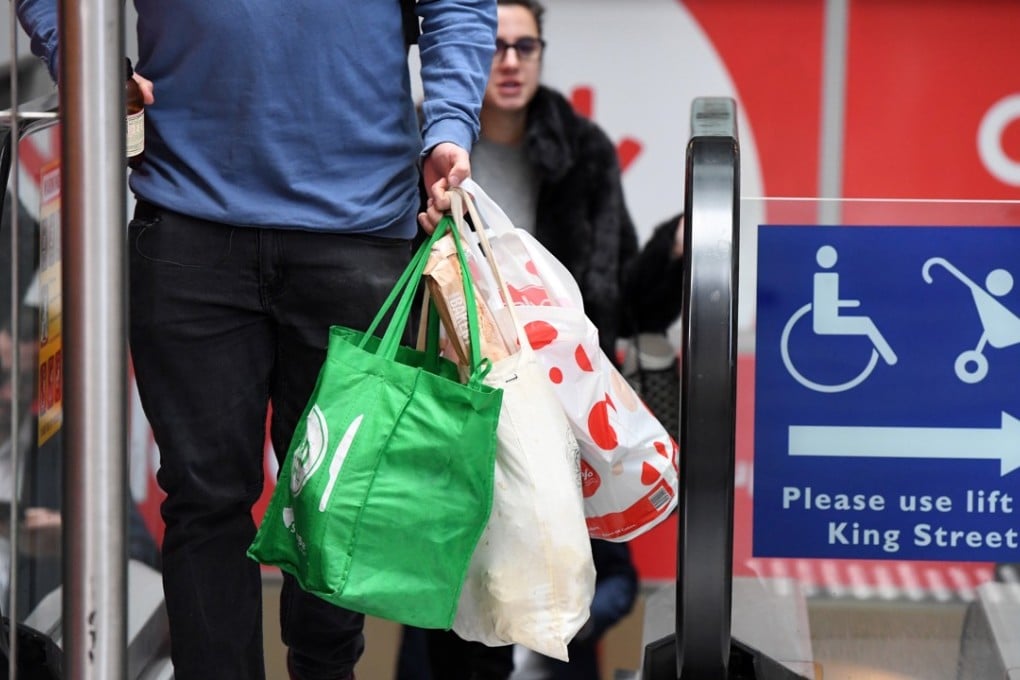 A shopper carries bags at a Coles Sydney central business district store. Photo: EPA
