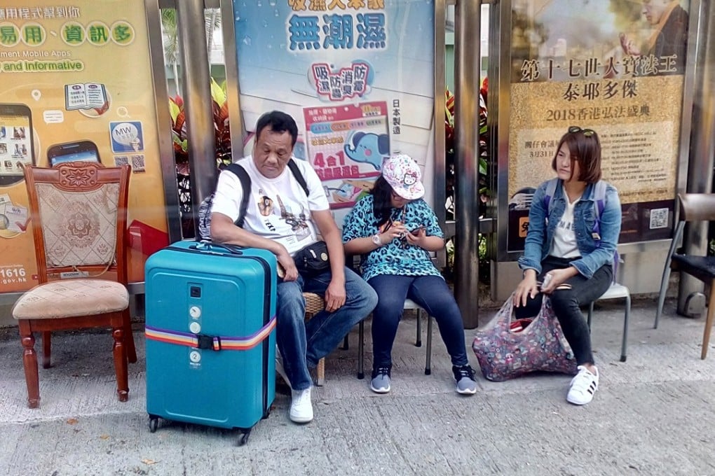 Passengers rest on discarded chairs as they wait at a bus stop in Ma Hang Estate, Stanley. Photo: Handout/Francois Moirez