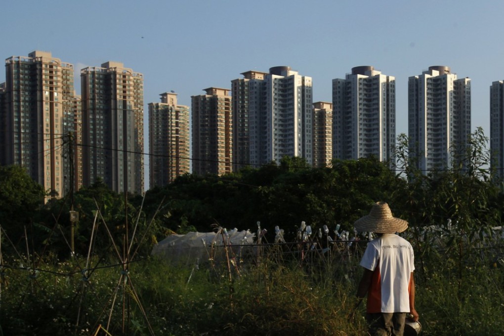 A New Territories resident stands at his farm in front of high-rise residential buildings. Photo: Reuters