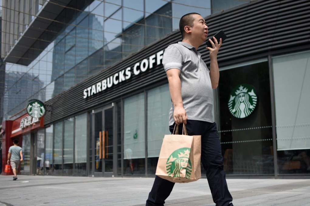 A man walks past a Starbucks coffee shop in Beijing on August 2, 2018. Starbucks has announced a partnership with e-commerce giant Alibaba that will give the US coffee giant greater access to China's growing food-delivery market as it faces increased competition. Photo: AFP