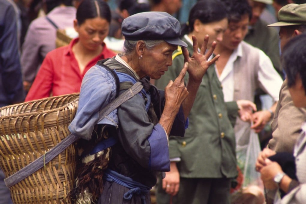 A Naxi woman uses hand gestures at a market in Lijiang, Yunnan province, China. Picture: Alamy