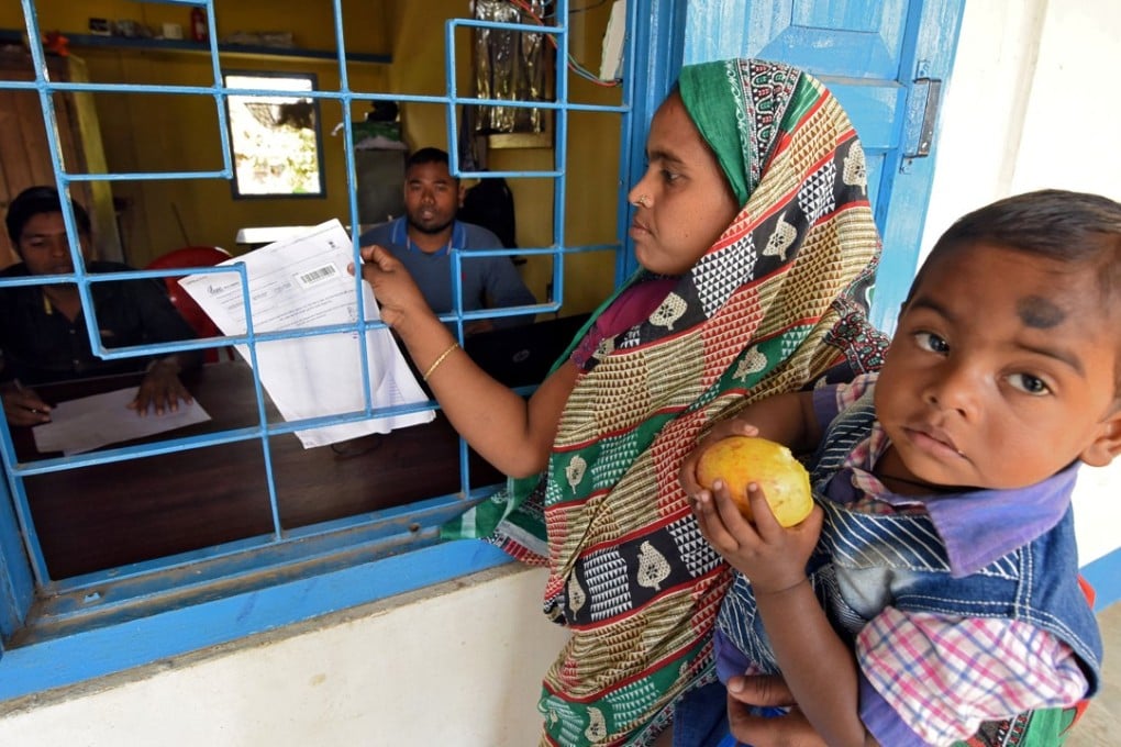 A woman in Assam checks whether her name is on the draft list of the National Register of Citizens. Photo: Reuters
