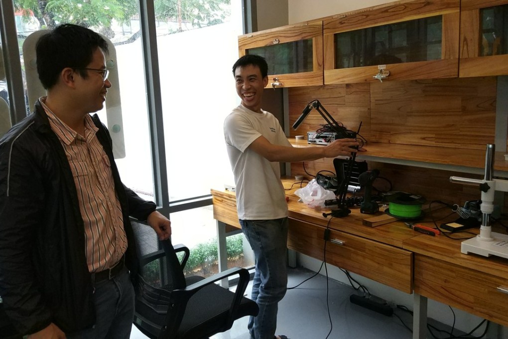 Nguyen Ba Hoi, left, shares a light moment with a colleague at Maker Innovation Space. Photo: Mai Duong