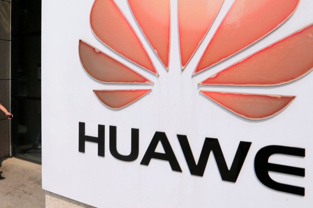 FILE PHOTO: A man walks past a Huawei company logo outside the entrance of a Huawei office in Wuhan, Hubei province October 9, 2012. REUTERS/Stringer/File Photo