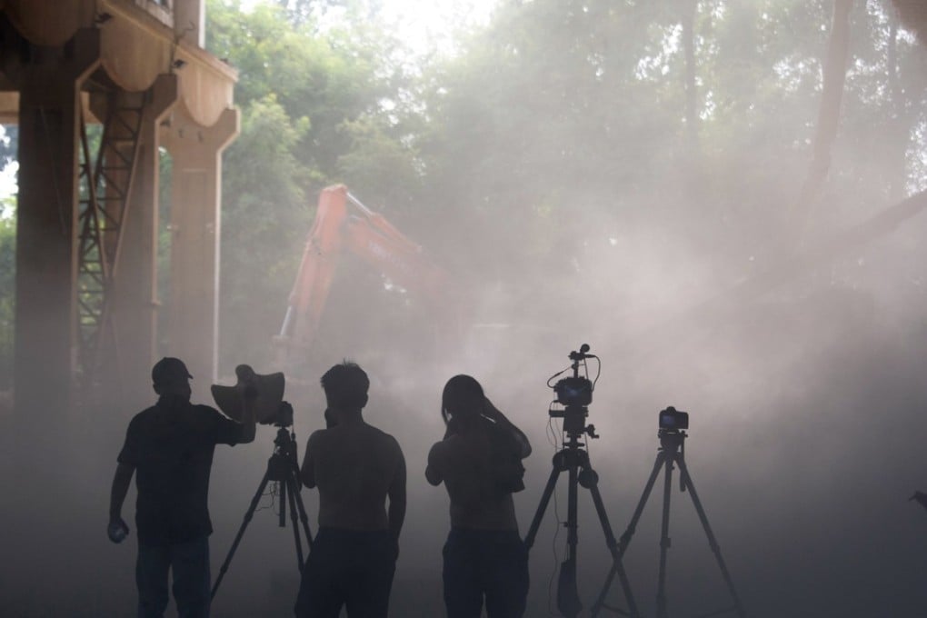 Workers film the demolition of Chinese artist Ai Weiwei's studio in Beijing on Saturday. Photo: AP