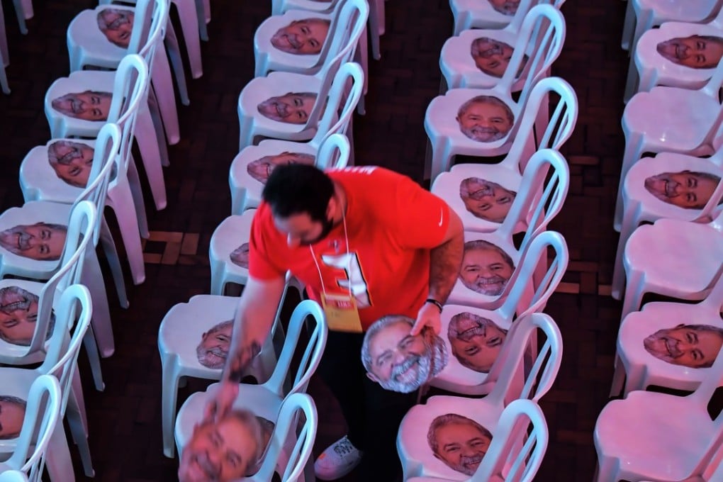 A man places masks of former Brazilian president Luiz Inacio Lula da Silva on chairs, before the national convention of the Workers Party, in Sao Paulo, Brazil on Saturday. Brazil's presidential election, starting with a first round on October 7, is seen as the most unpredictable in decades. Photo: AFP