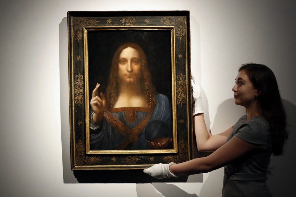 A Christies employee poses with ‘Salvator Mundi’, which is attributed to Leonardo da Vinci. But an Oxford historian disputes the claim. Photo: AP