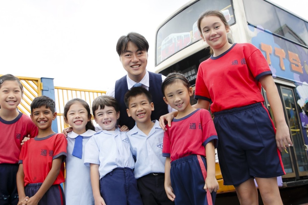Principal Wong Wai-lap (back centre) with primary schoolchildren in front of their KMB bus library at Tung Tak School in Hong Kong’s New Territories. Photo: Raymond Mak