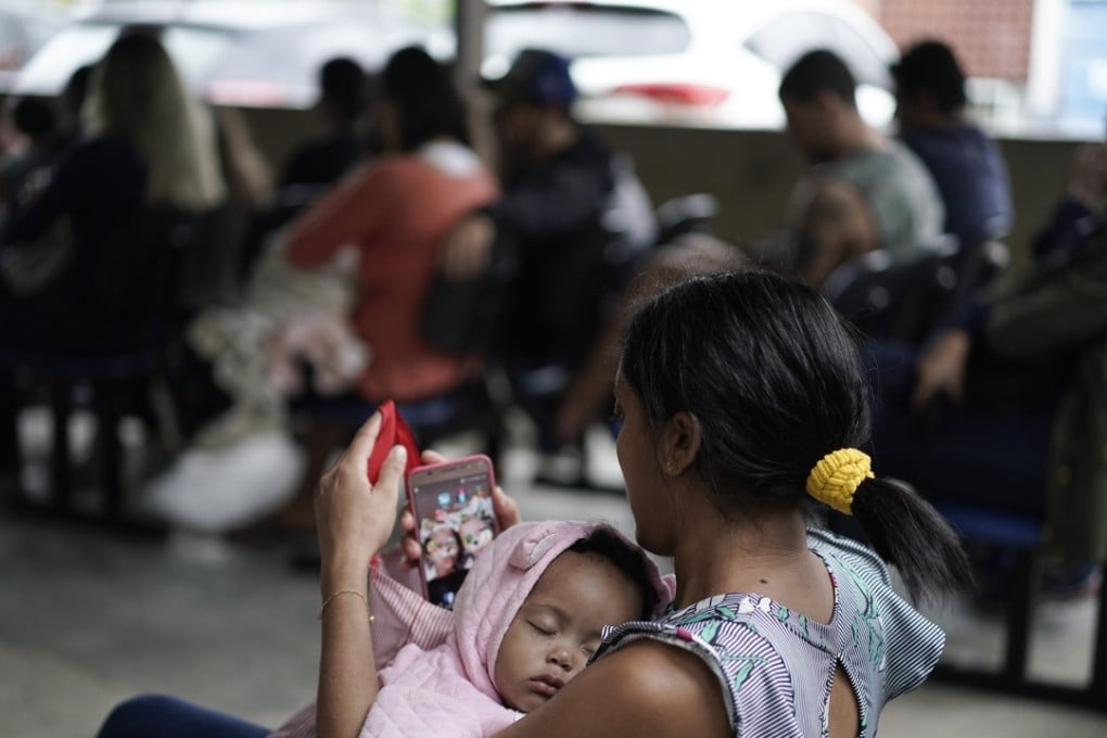 A mother cradles her baby as they wait to receive a vaccine against polio in Rio de Janeiro, Brazil, on Monday. Brazilian health authorities have launched a nationwide vaccination campaign against measles and polio. Photo: AP