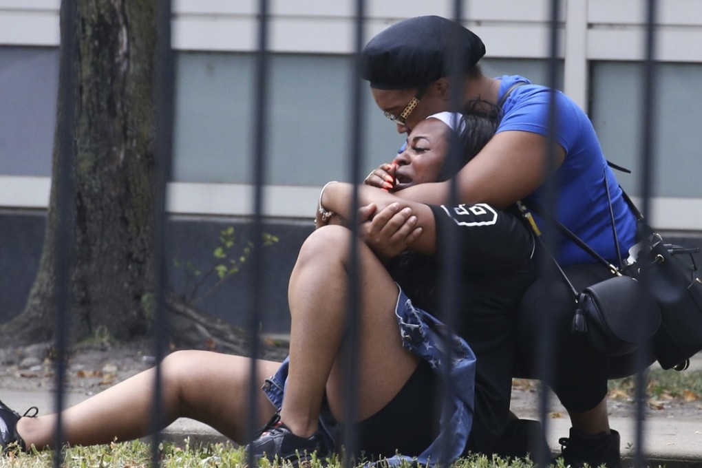 Two women cry outside the Stroger Hospital in Chicago, after they were asked to leave due to overwhelming crowds of family and friends of shooting victims on Sunday. Photo: AP