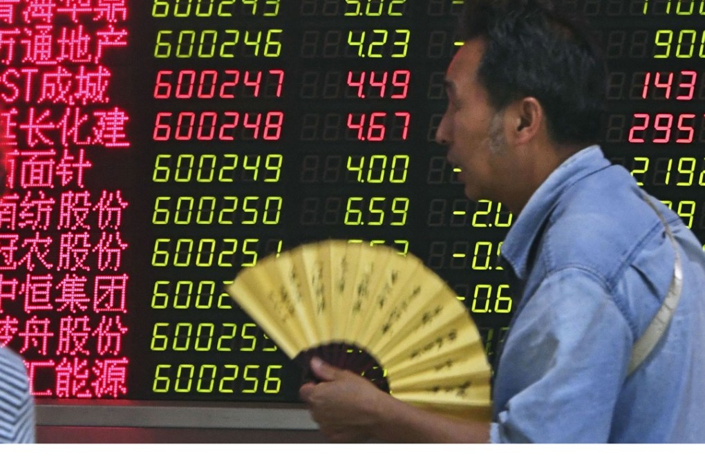 Investors look at an electronic board showing Shanghai stock prices at a brokerage house outlet in Beijing. Photo: Kyodo
