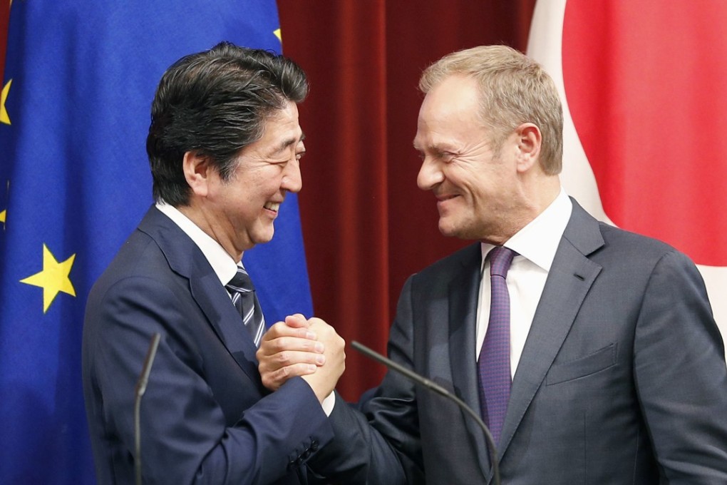 European Council president Donald Tusk and Japanese Prime Minister Shinzo Abe shake hands at Abe's office in Tokyo on July 17 after Japan and the European Union signed a free trade deal. Photo: Kyodo