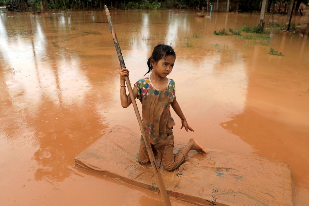 A girl uses a mattress as a raft in Attapeu province, Laos. Photo: Reuters
