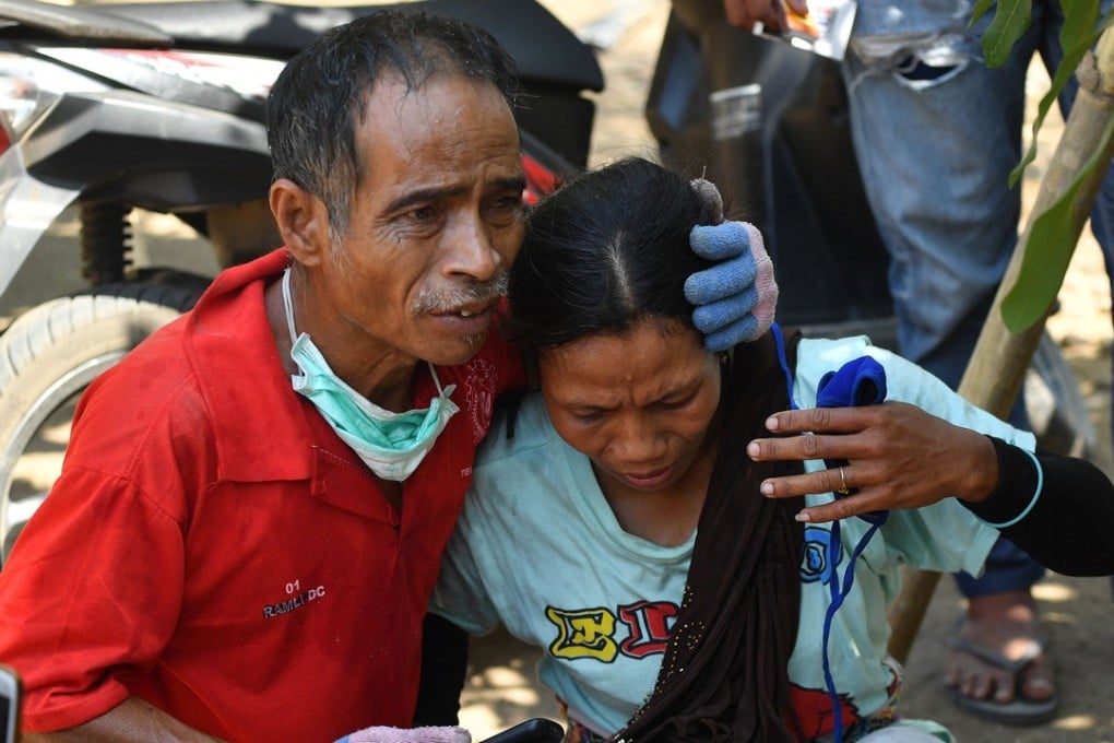 A man tries to calm a woman after an aftershock hit the area in Tanjung on Lombok island. Photo: AFP