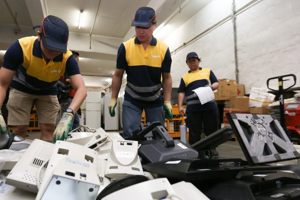 Employees at the Waste Electronic and Electrical Equipment recycling facility run by Alba sort through boxes of electronic waste. Photo: Xiaomei Chen