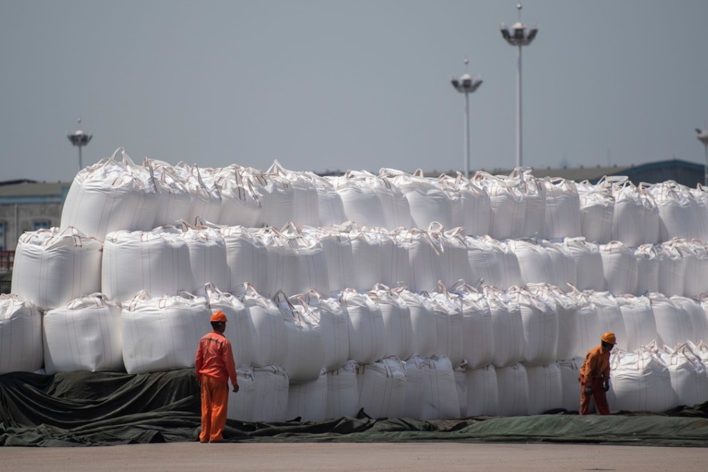 Workers cover bags of chemicals at a port in eastern Jiangsu province. China and the US are locked in a trade war that has shown no sign of abating. Photo: AFP
