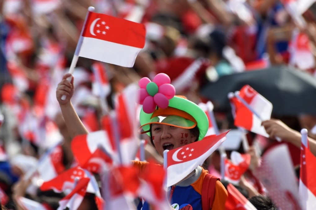 Spectators wave Singaporean flags during their country’s 52nd National Day parade and celebration in Singapore last year. Photo: AFP
