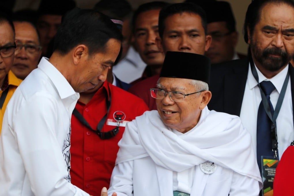 Indonesian President Joko Widodo, left, with his vice-presidential running mate Ma’ruf Amin while greeting supporters in Jakarta on Friday. Photo: Reuters