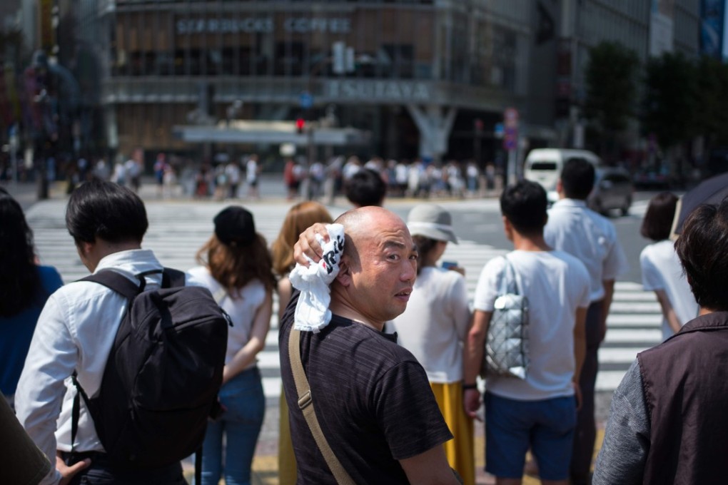 Pedestrians feel the heat at the Shibuya crossing in Japan. Photo: AFP