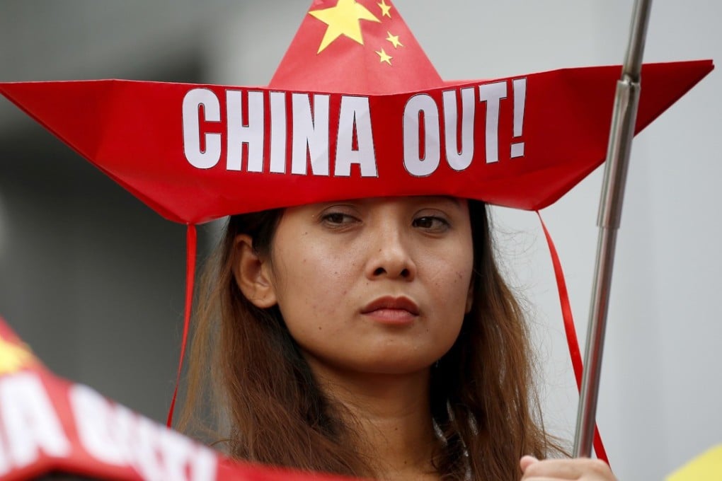 A Philippine protester, wearing a boat-shaped hat, demonstrates against China’s military moves in the South China Sea. Photo: AP