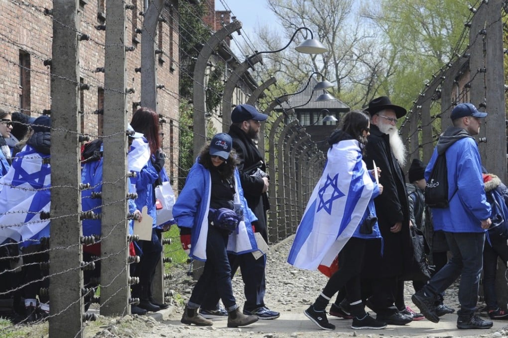 Jews from Israel and around the world participating in the annual “March of the Living” to commemorate the Holocaust victims walk through a barbed wire fence in the former German Nazi death camps of Auschwitz-Birkenau, in Poland on April 24, 2017. Photo: AP