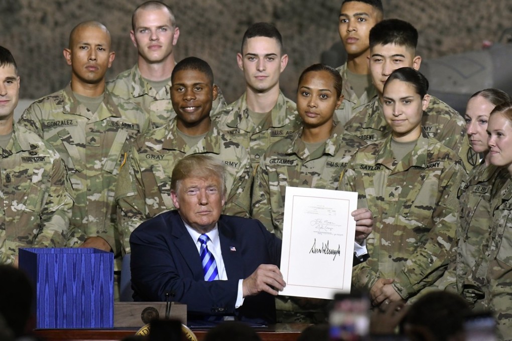 US President Donald Trump signs the John McCain National Defence Authorisation Act at a ceremony on Monday in Fort Drum, New York. Photo: AP