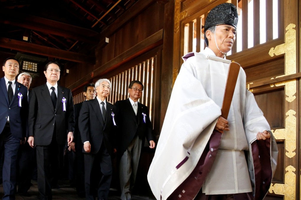 A Shinto priest accompanies Japanese lawmakers as they visit Yasukuni Shrine. Photo: Reuters