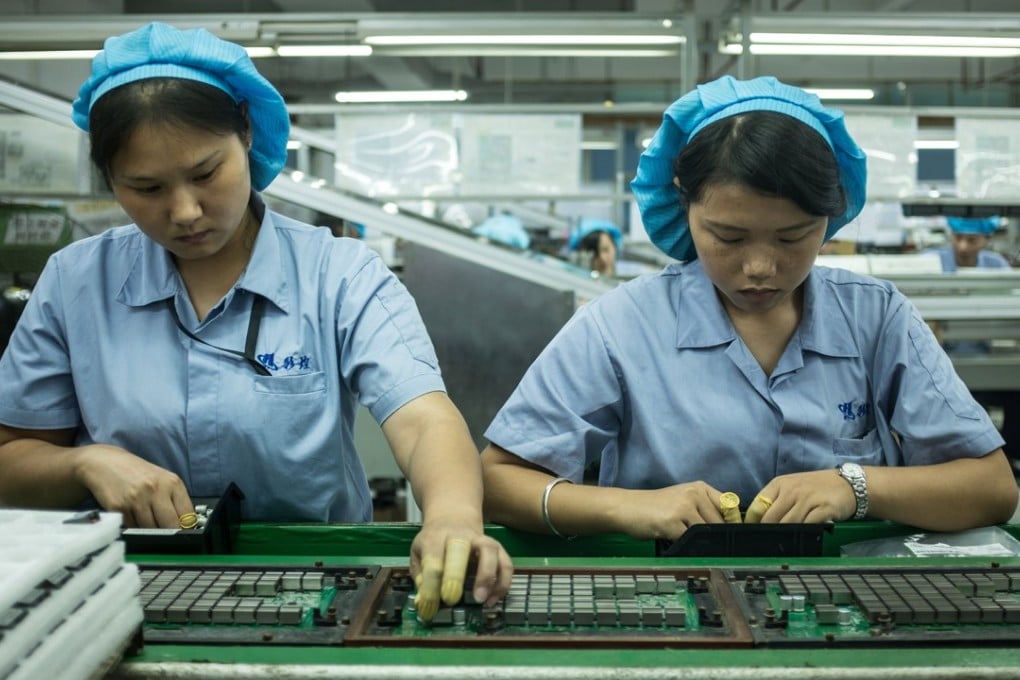 Employees mount cooling chips to circuit boards on an assembly line of cryptocurrency mining machines at Bitmain Technologies’ manufacturing base in Shenzhen. Photo: EPA