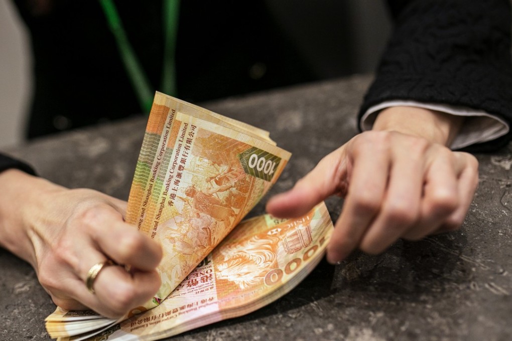 Under its currency board system, the Hong Kong Monetary Authority must keep the local currency within a trading range between 7.75 to 7.85 per dollar. Above: an employee counts Hong Kong one thousand dollar banknotes. Photo: Bloomberg