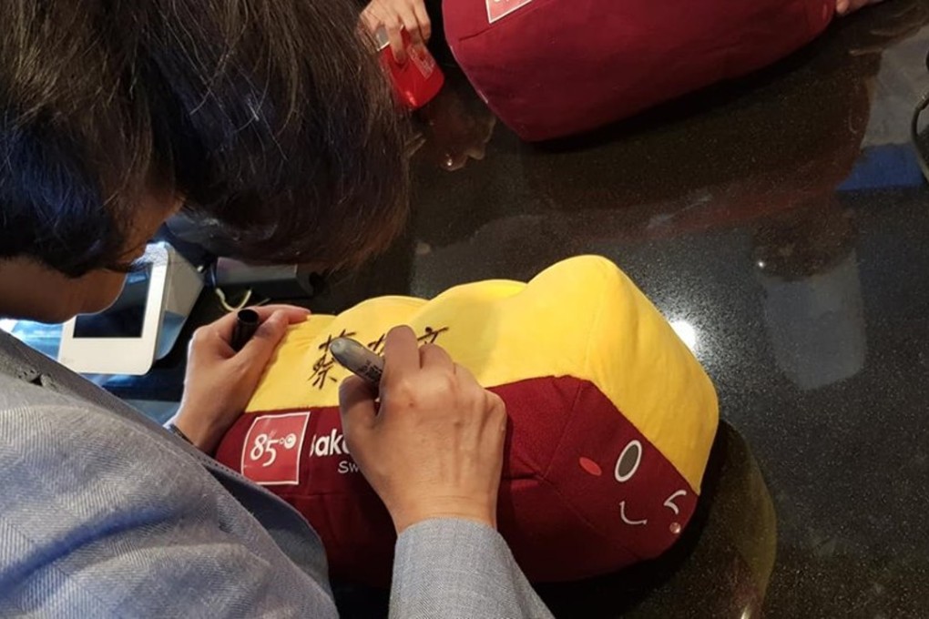 Taiwanese President Tsai Ing-wen autographs a souvenir at the 85C coffee shop in Los Angeles. Photo: Facebook