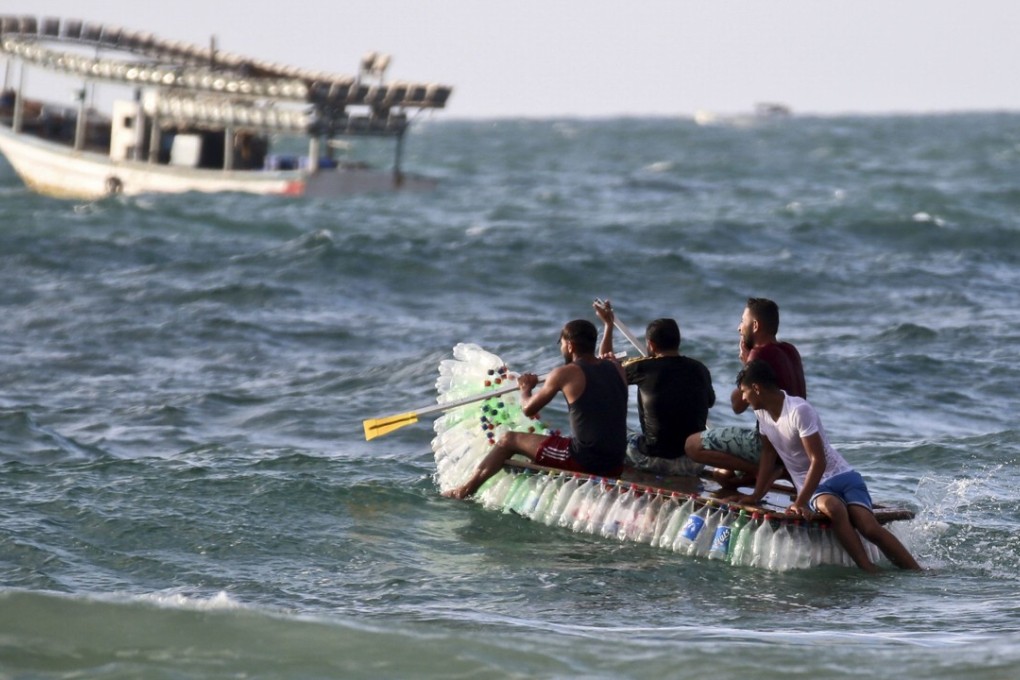 Palestinian fisherman Muath Abu Zeid and his friends head out to sea on his boat made of 700 plastic bottles. Photo: Agence France-Presse