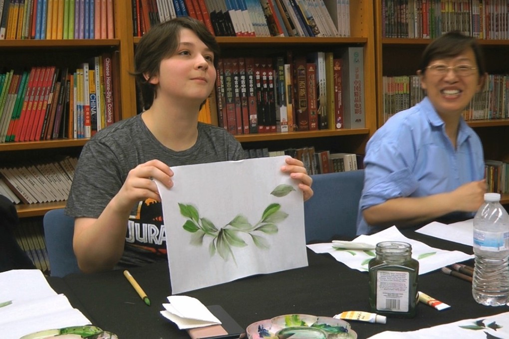 Undergraduate student Moe Lewis, left, shows her watercolour painting of peony leaves at a traditional Chinese painting class at the Confucius Institute at George Mason University in Fairfax, Virginia, on May 2, 2018. Photo: AP