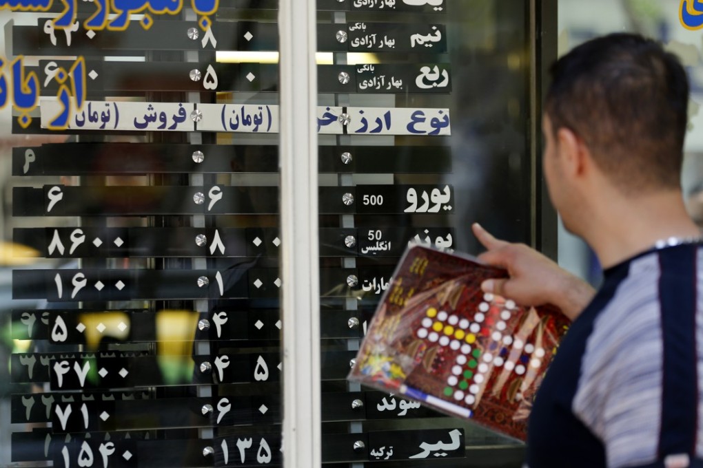 Iranians check exchange rates outside a bank in Tehran. Photo: AFP