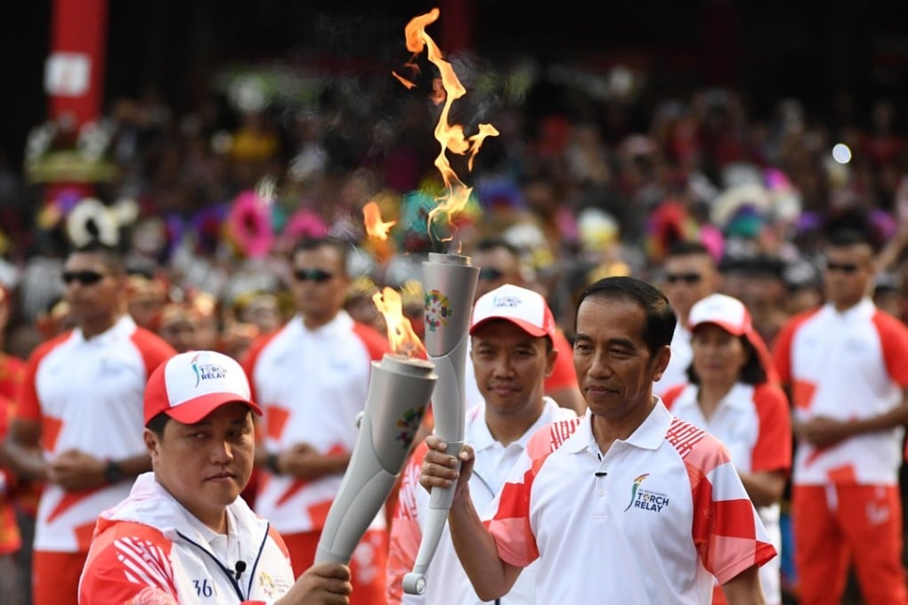 Indonesian President Joko Widodo (right) and Asian Games organising committee chief Erick Thohir with the Asian Games torch. Photo: AFP