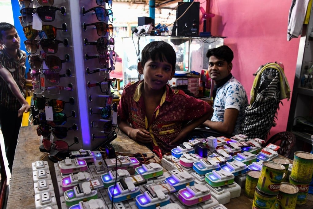 A Rohingya refugee man works inside his mobile charging shop in the Kutupalong camp in Cox's Bazar. Photo: AFP