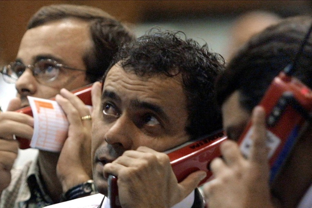 Traders on the phone on 20 June 2002 at the Sao Paulo Stock Exchange (Bovespa) in Sao Paulo, Brazil. Rating agency Moody's Investors Service said 20 June 2002 it had cut its outlook for Brazil's foreign currency credit ratings to "negative" from "stable" because of deteriorating investor sentiment. Investors' confidence has been undermined by "perceived uncertainties associated with the outcome of the October election," the agency said, "despite the present government's maintenance of a sound macroeconomic policy mix." Photo AFP