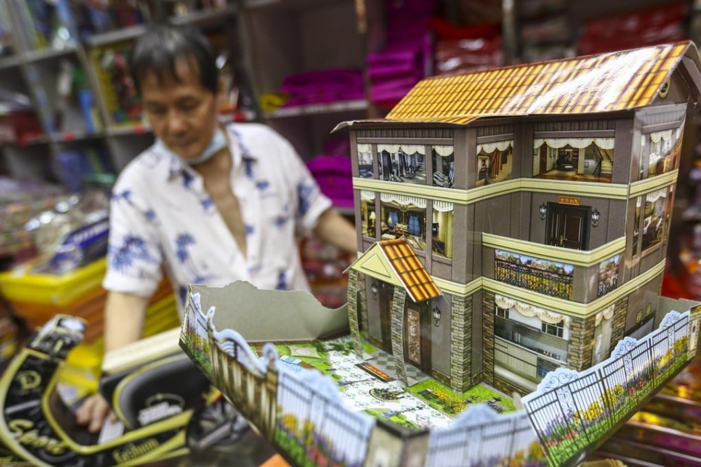 A shop owner in Sai Ying Pun displays a paper offering depicting “luxurious” subdivided flats to be burned during this year’s Hungry Ghost festival. A government study in January 2018 found 210,000 people live in subdivided flats in Hong Kong, not including the estimated 40,000 residents of “cage homes”. Photo: Nora Tam