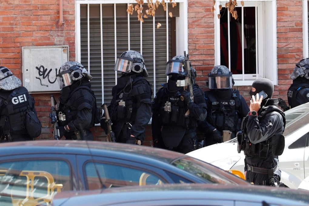 Officers take part in the search of the residential building where the attacker lived in Cornella, Spain. Photo: EPA-EFE