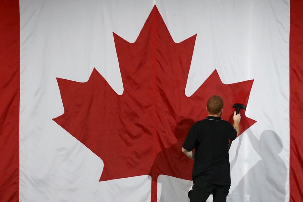 A worker steam cleans a Canadian flag at a political rally in Montreal in 2015. Photo: Reuters