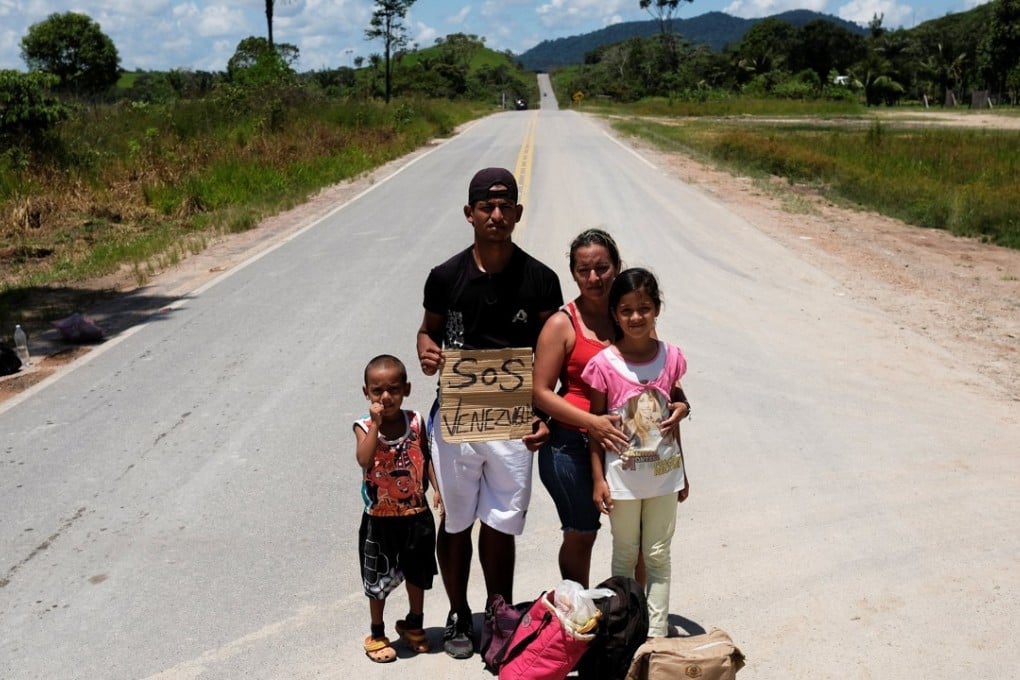 A Venezuelan family from Aragua state pose for a picture as they attempt to hitchhike toward Boa Vista city in Brazil. Photo: Reuters
