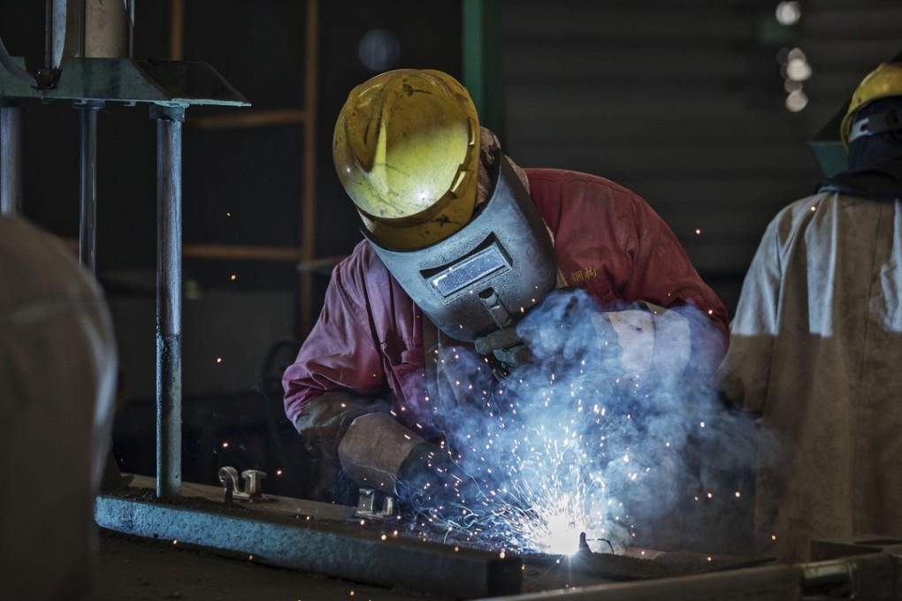 A worker assembles an end frame for a shipping container at a Singamas factory in China. The company reported a loss for the first half of 2018. Photo: Bloomberg